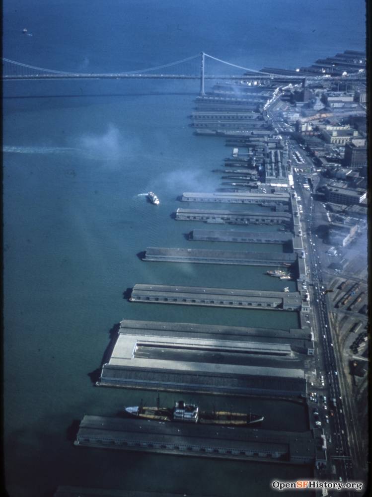 C1955 Aerial view looking south toward Bay Bridge, Belt Line Railroad yard at lower right. Ferry Building with vehicle underpass in front wnp25.2056.jpg