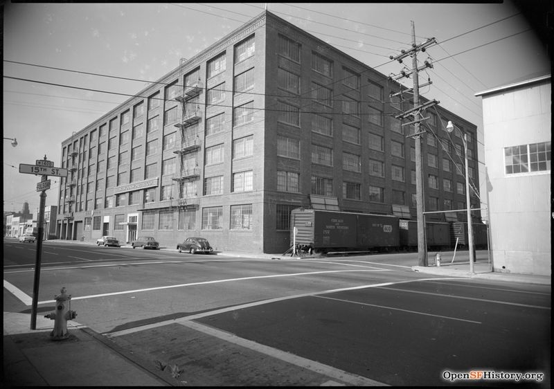 C 1955 View toward Northeast Corner of 15th and Folsom. Woolworth Company warehouse with railroad boxcars on 15th, presently occupied by the University of California San Francisco Mission Center. wnp100.00107.jpg