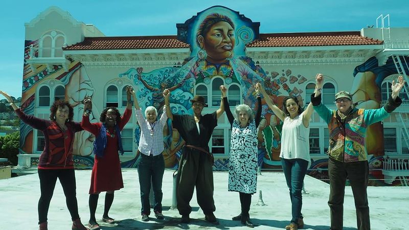 Womens Building artists on roof in front of mural.jpg