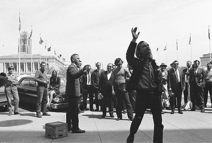 Peter-Berg-outside-City-Hall-with-hand-upraised 00050035 Chuck-Gould.jpg