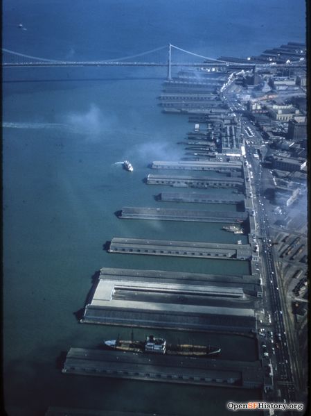 File:C1955 Aerial view looking south toward Bay Bridge, Belt Line Railroad yard at lower right. Ferry Building with vehicle underpass in front wnp25.2056.jpg