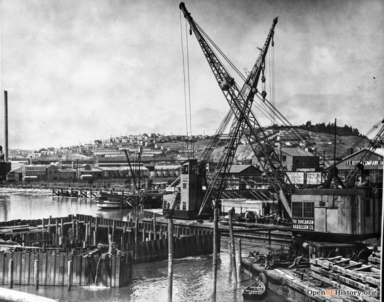 File:View Northwest from Islais Creek Bridge, 3rd Street. Duncanson-Harrelson Co. cranes, F. E. Booth Company (sardine cannery), Cargill warehouses. Potrero Hill with public housing in distance 1950s wnp37.03830.jpg