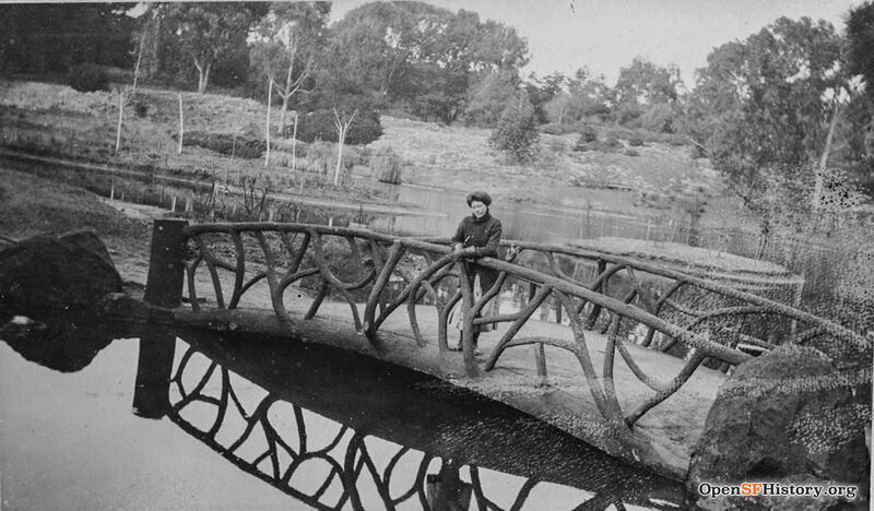 Woman posing on concrete rustic bridge, likely on North Lake in Golden Gate Park.opensfhistory wnp37.03245.jpg
